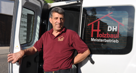 Damir Huremovic vor Fuhrpark von DH-Holzbau